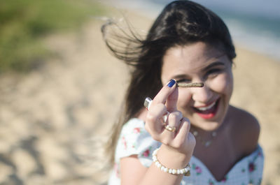 Portrait of young smiling woman showing marijuana joint outdoors