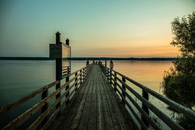 Pier over sea against sky during sunset