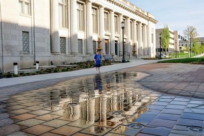 Boy standing against nebraska state capitol building 