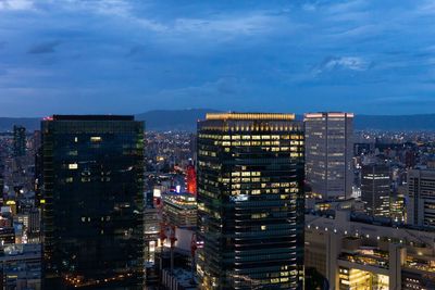 High angle view of illuminated buildings against sky at dusk