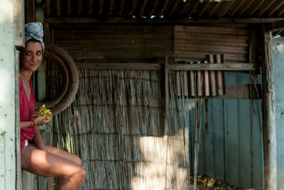 Full length of woman sitting on wood