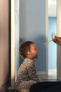 Cropped hand feeding son at home