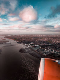 Aerial view of cityscape against sky with jet engine