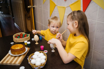 Brother and sister color easter eggs