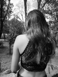 Rear view of woman standing in forest