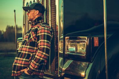 Rear view of man standing in car