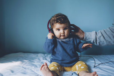 Cute girl listening music on headphones at home