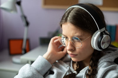 A young girl listens to every sound of the musical piece she is listening to.