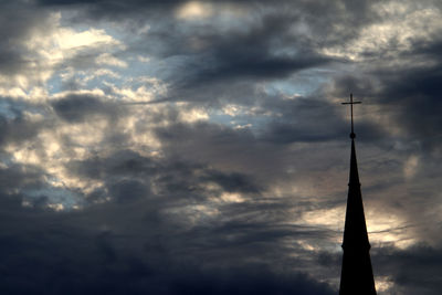 Low angle view of silhouette tower against dramatic sky