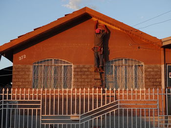 Low angle view of man working on building