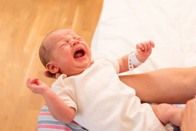 High angle view of baby boy lying on bed at home