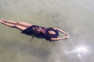 High angle view of young woman floating in sea
