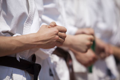 Midsection of people performing karate
