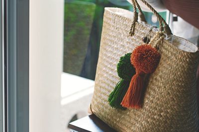 Close-up of wicker bag on table by window