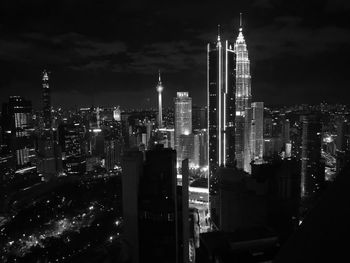 Illuminated buildings in city against sky at night