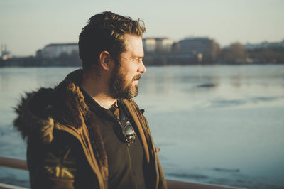 Thoughtful man in warm clothing by lake