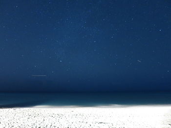 Scenic view of sea against star field at night