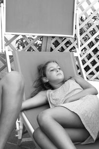 Girl looking away while relaxing on lounge chair