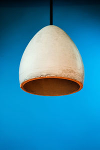 Low angle view of electric lamp against blue sky