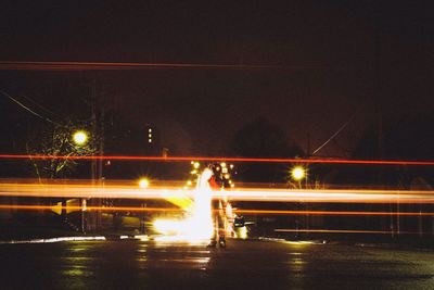 Light trails on road against sky at night