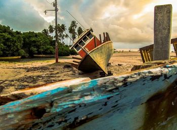 Boats in calm sea against cloudy sky