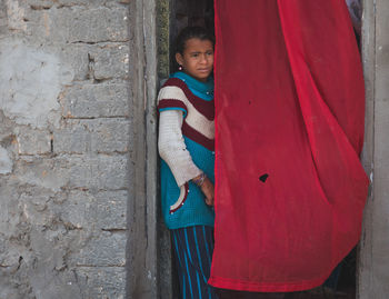 Portrait of boy standing against wall