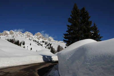 Scenic view of snow covered mountains against clear blue sky