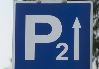 Close-up of arrow sign on road