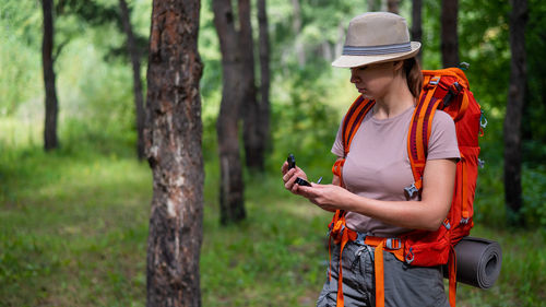 Midsection of man using mobile phone on tree