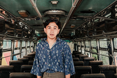 Portrait of young man standing in bus