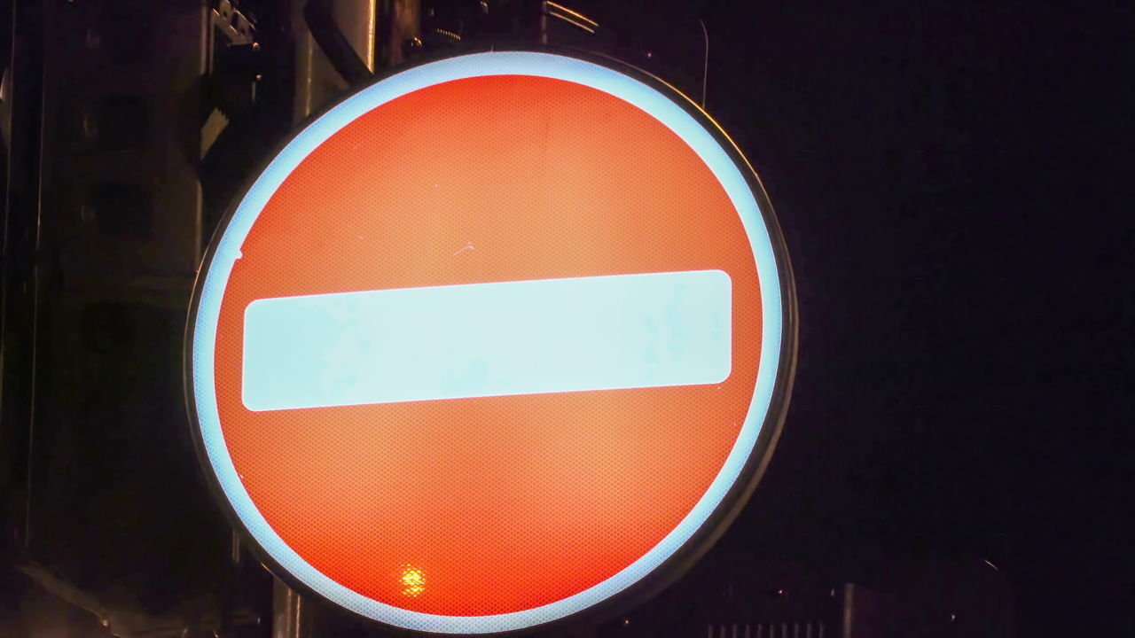 CLOSE-UP OF ROAD SIGN AGAINST RED BACKGROUND