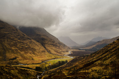 Scenic view of mountains against cloudy sky