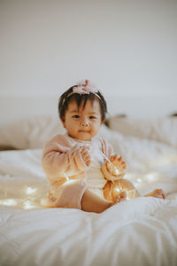 Cute baby girl on bed at home