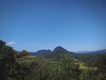 Scenic view of mountains against clear blue sky
