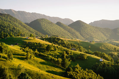 Scenic view of summer landscape and mountains against sky in the morning