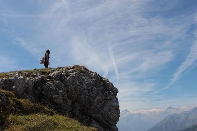 Woman standing high up at edge of mountain