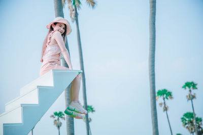 Low angle view of woman standing against sky