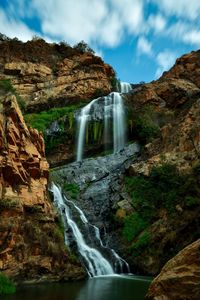 Idyllic shot of waterfall against sky