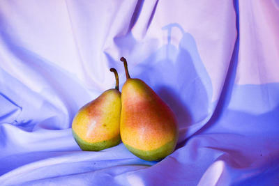 Two pears on the table with a tablecloth 