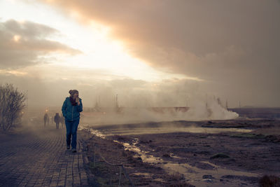 Rear view of two men standing on beach