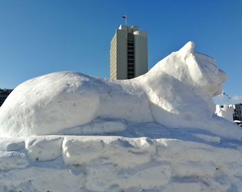 Snow covered buildings against sky