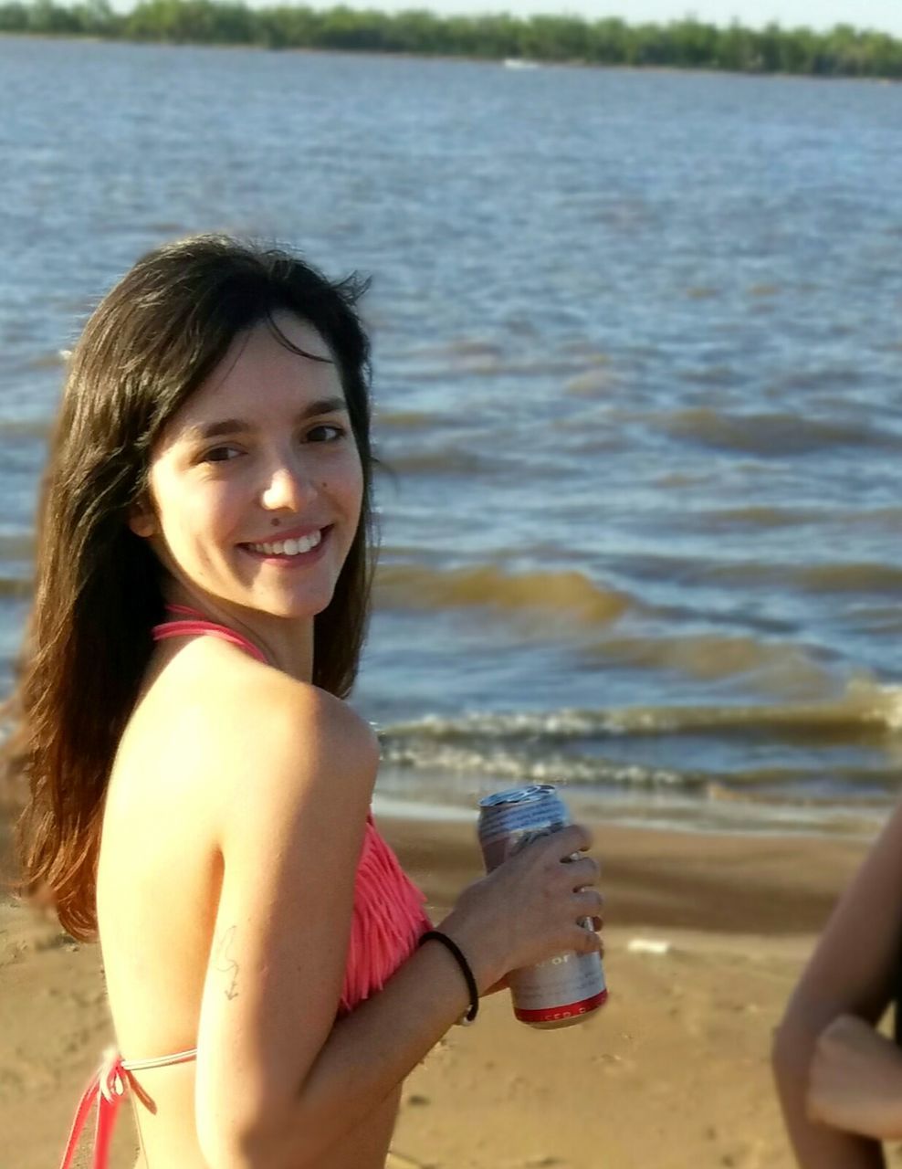 one person, looking at camera, smiling, drink, real people, water, bottle, portrait, beach, food and drink, happiness, holding, refreshment, drinking, leisure activity, outdoors, water bottle, lifestyles, day, childhood, sea, sand, vacations, cheerful, young adult, young women, nature, food, close-up, people