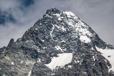 Low angle view of snowcapped mountain against sky