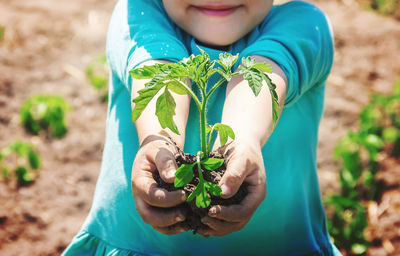 Midsection of woman holding plant