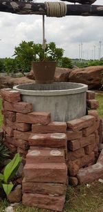 Stack of potted plant on field against sky