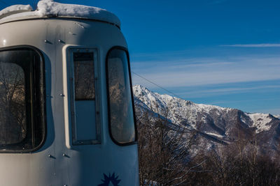Close-up of car on snow covered mountain against sky