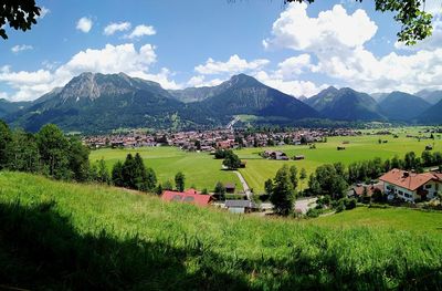Scenic view of field and houses against sky