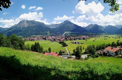 Scenic view of field and houses against sky