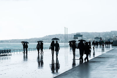 People on shore against sky