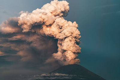 Smoke emitting from volcanic mountain against sky